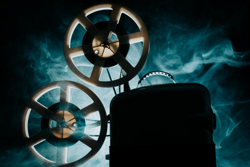 Retro projector playing motion picture in dark room.