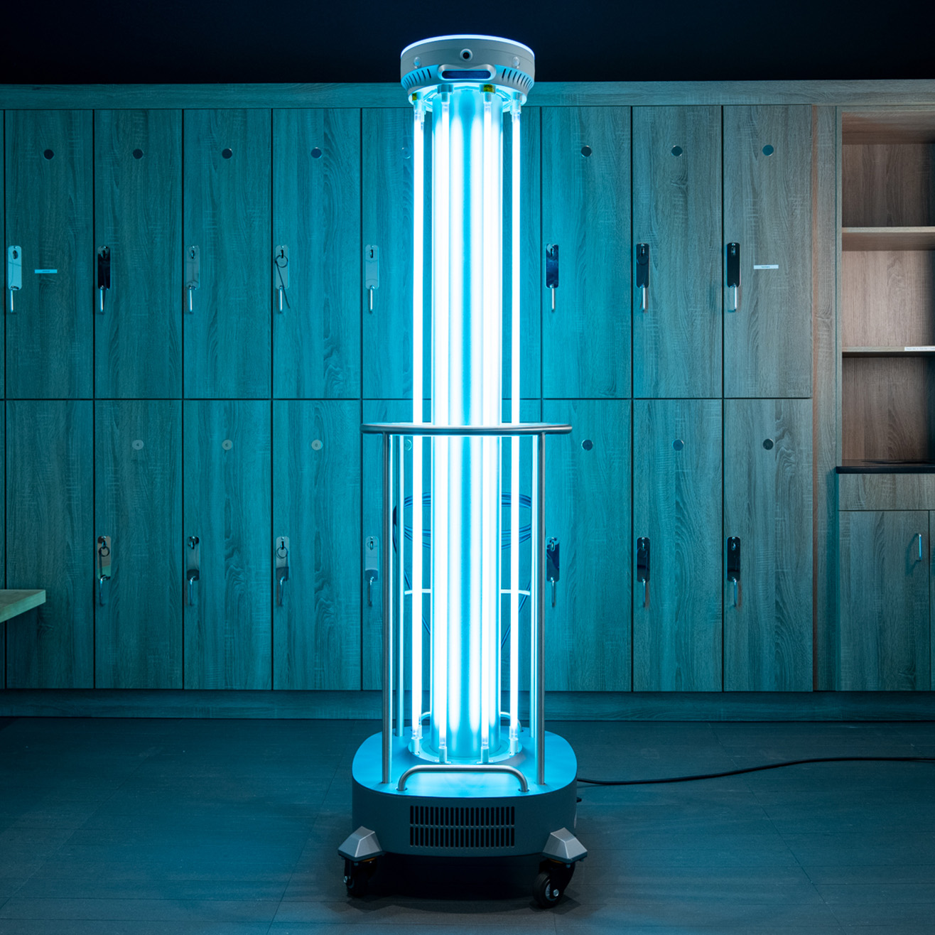An ADIBOT S1 UV-C disinfection robot with UV-C lamps turned on in a gym locker room.