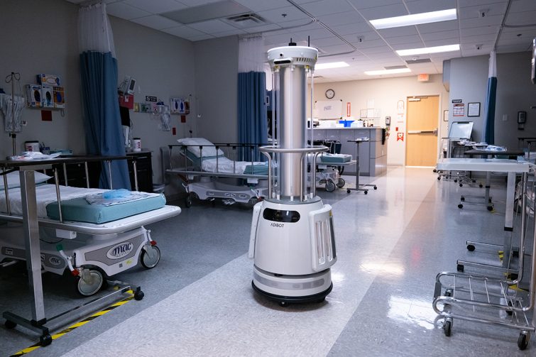 The ADIBOT A1 fully autonomous UV-C disinfection robot traveling down the center of a hospital patient ward.