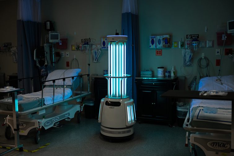 The ADIBOT A1 fully autonomous UV-C disinfection robot with UV-C lamps on disinfecting the space between two hospital beds.